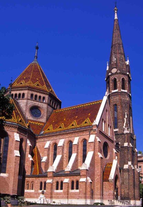 Chiesa in mattoni rossi con campanile e cupola con vertici appuntiti della chiesa calvinista.