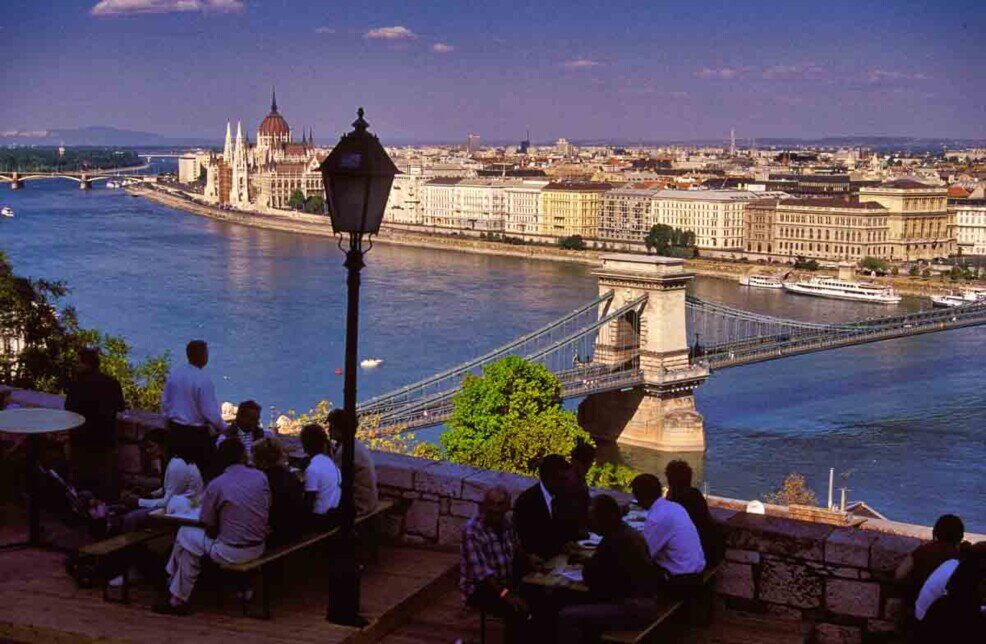 Il Danubio visto dal Palazzo Reale con gente seduta ai tavolini e sullo sfondo il ponte delle catene.