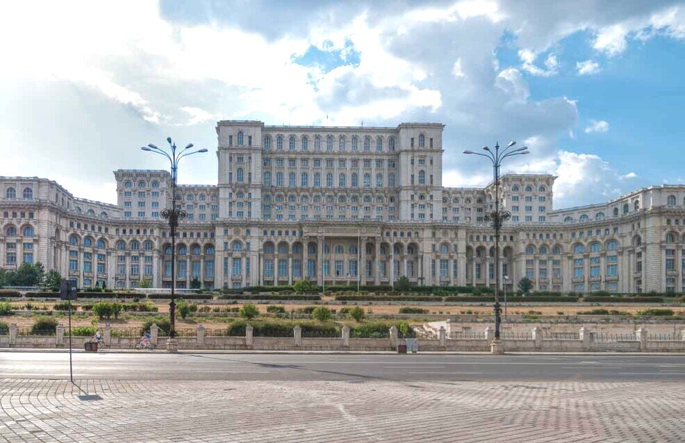 Grande edificio semicircolare con davanti una grande piazza.