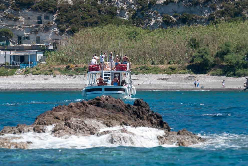 Una battello pieno di turisti sta per approdare a Cala del Porto nota spiaggia dell'isola di Palmarola.