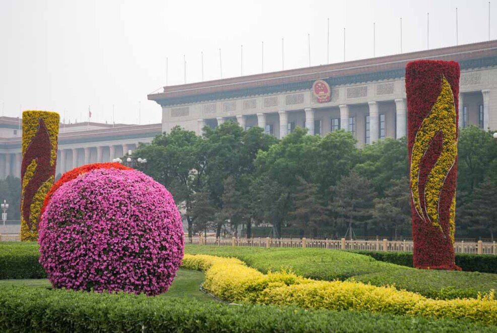 Giardino ben ccurato con sullo sfondo il palazzo dell'assemblea nazionale del popolo di Pechino.