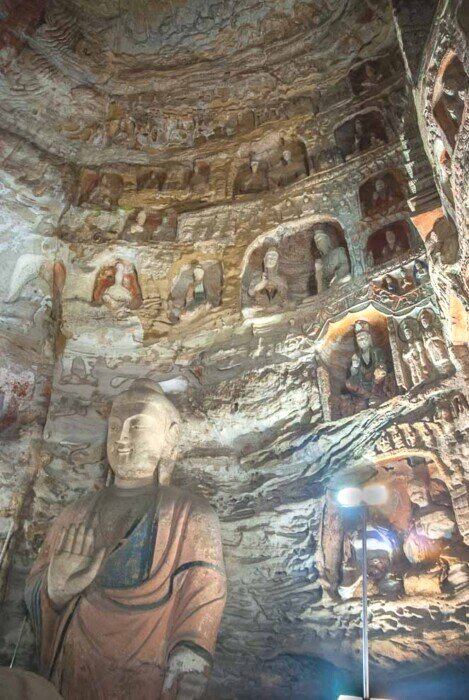 Statua del Buddha del passato-circondato da decine di nicchie di altri Buddha tutti diversi.