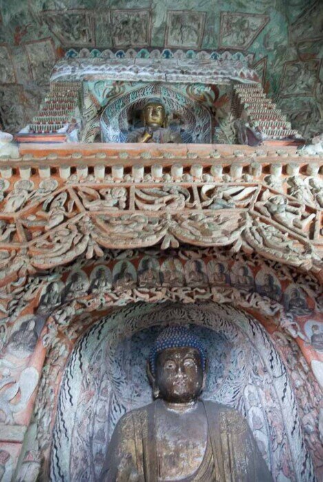 Statue di Buddha in due nicchie sovrapposte nella grotta di Yungang.
