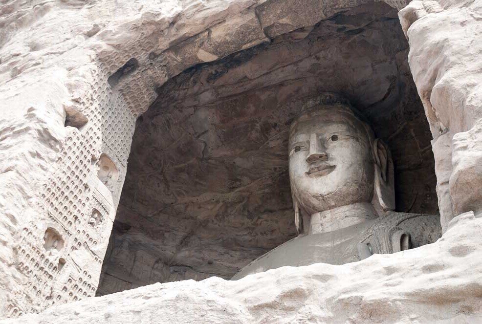 Da una apertura della grotta di Yungang si intravede il viso di un buddha.