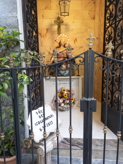 Un  tabernacolo con il busto di Gesù con ai piedi un cesto di fiori in ceramica in vico Lammatari a Napoli.