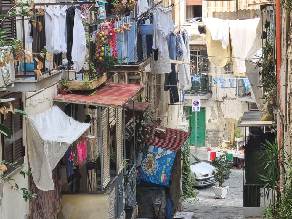 Scalinata in discesa con ai lati balconi e terrazze con roba stesa ad asciugare nel tipico quartiere sanità di Napoli.