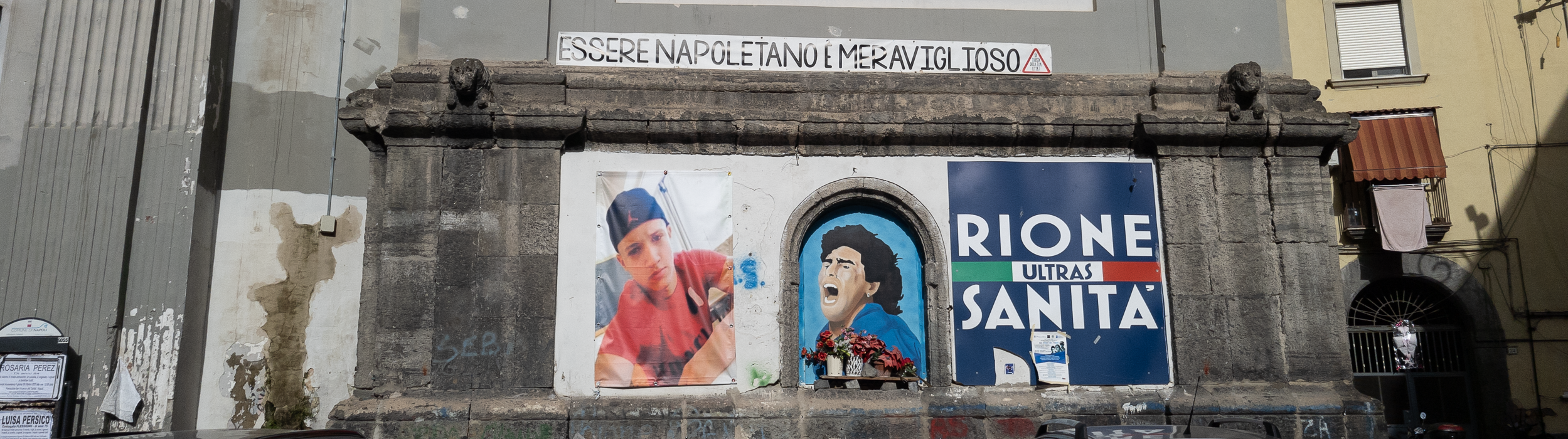 Manifesto su un muro con la scritta-essere napoletani è meraviglioso- con una foto di Maradona a Napoli.