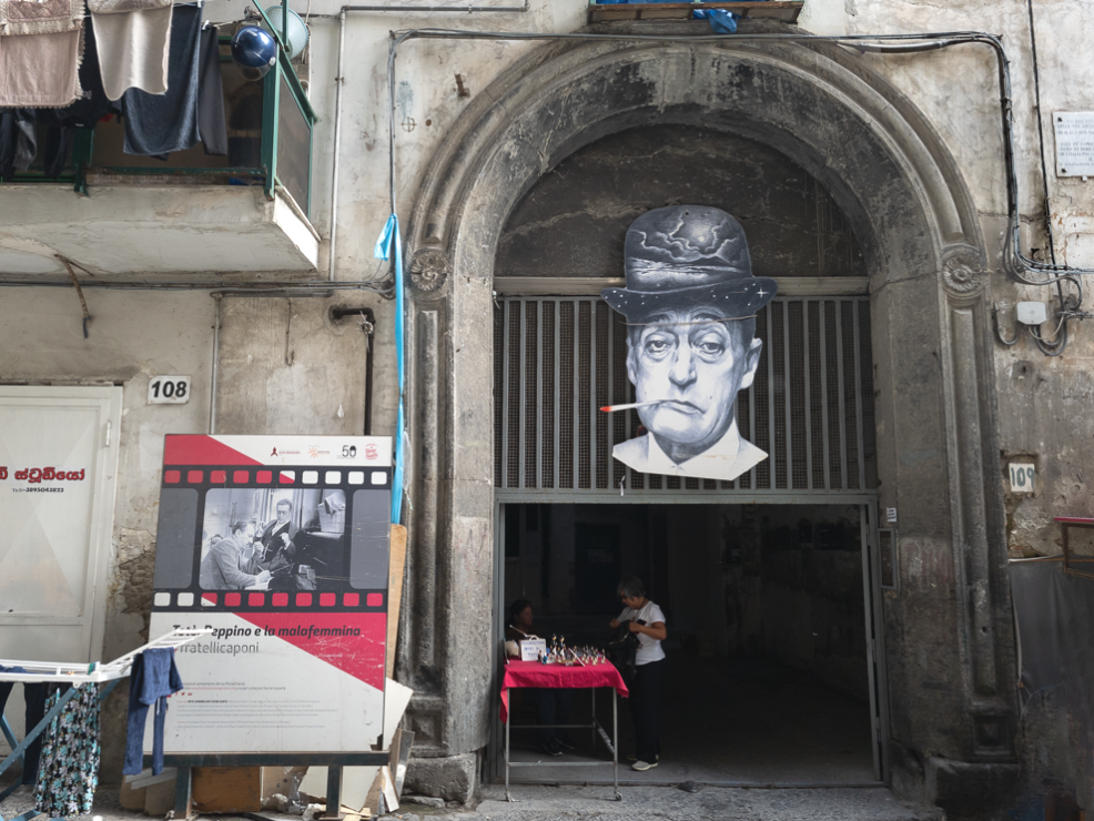 Una grande foto di Totò con cappello e sigaretta all'ingresso del palazzo che ospitava la casa di Totò.