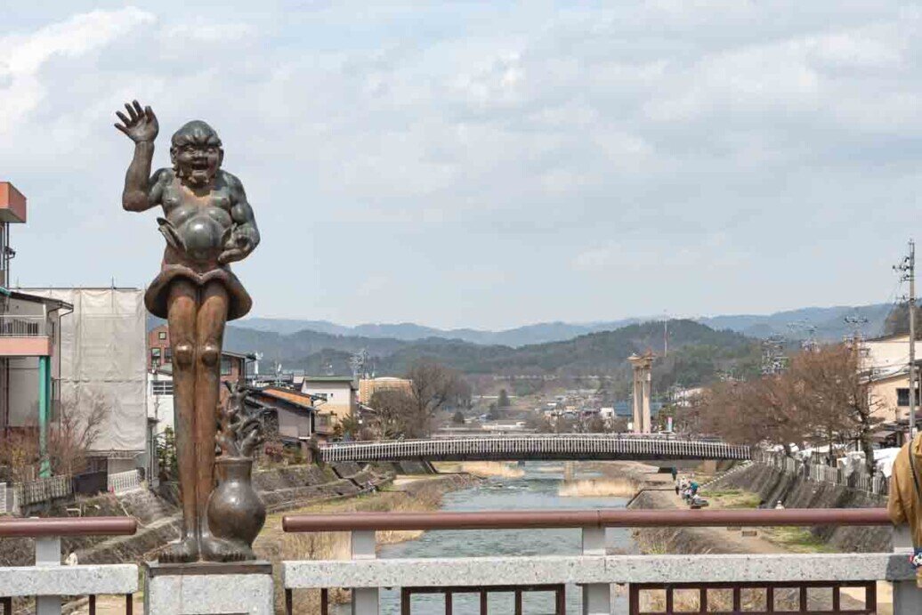 Statua allegorica sul ponte attraversato dal fiume Miya-gawa di Takayama