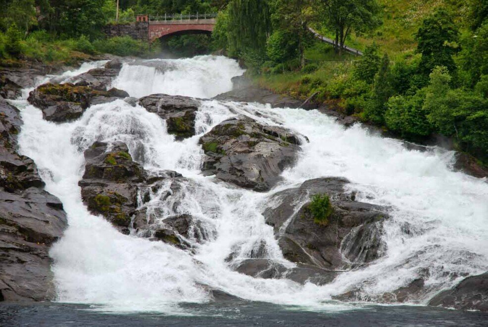 Irruente flusso d'acqua della cascata di Hellesylt che si getta sulle rocce di granito.