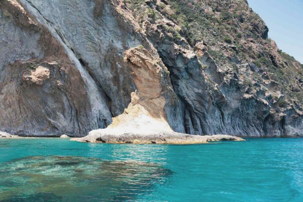 Uno scoglio sottile e alto con la base larga che si erge sul mare smeraldo dell'Isola di Palmarola.