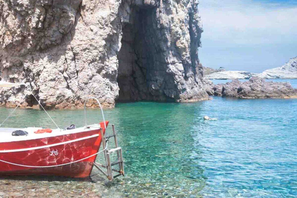 Prua di una barca ancorata di fronte ad una grotta sull'Isola di Palmarola.