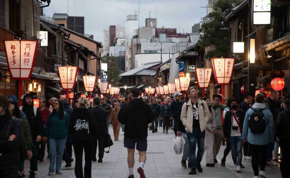 Lanterne rosse illuminate ai lati di una strada di Kyoto.