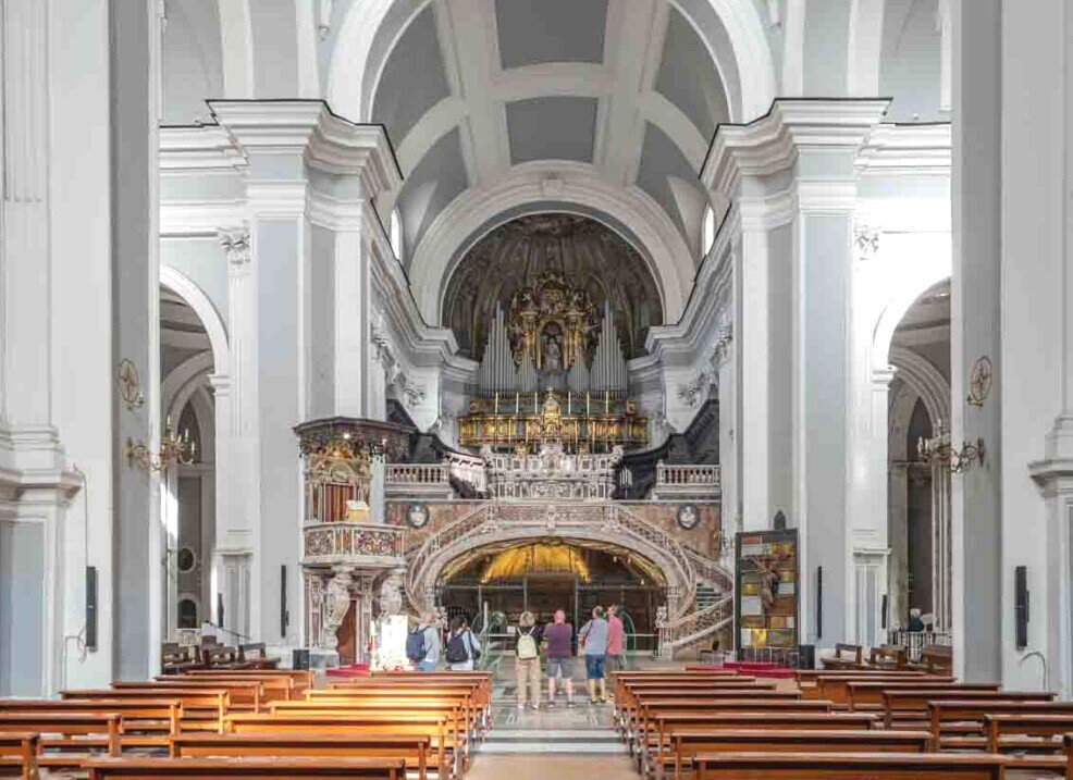 Interno della chiesa con banchi di legno e grande organo.