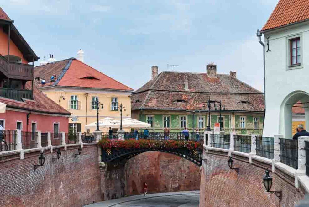 Un ponte che sovrasta una strada con case colorate sullo sfondo.