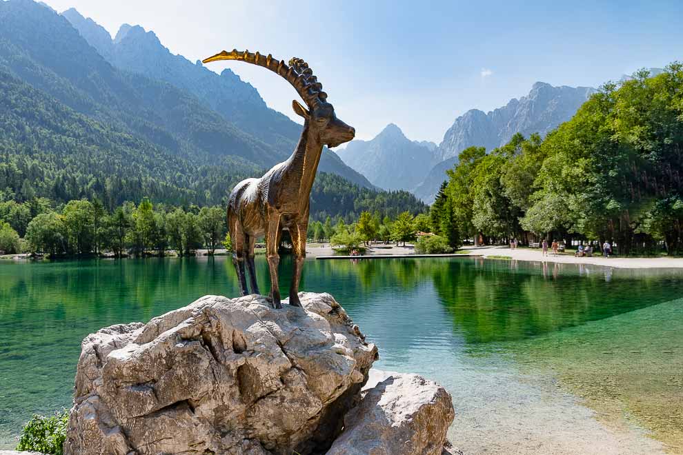 Kranjsca-Gora-statua di un cervo dalle corna color oro con lo sguardo rivolto al lago vicino.